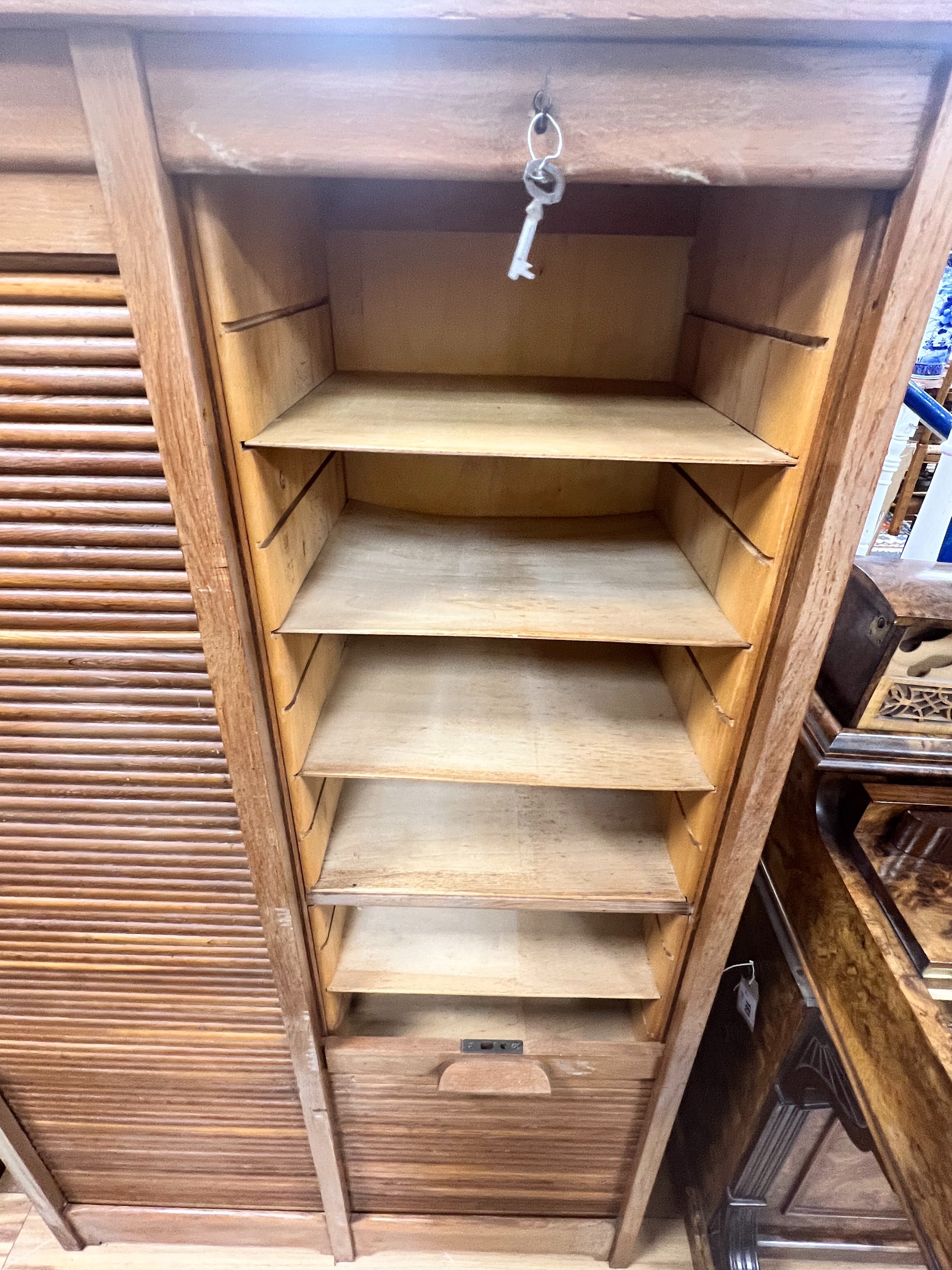 A mid century oak double tambour filing cabinet, width 87cm depth 38cm height 143cm